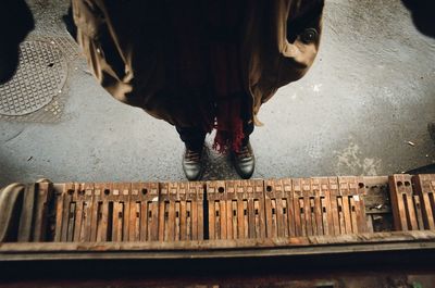 Low section of man standing on wood