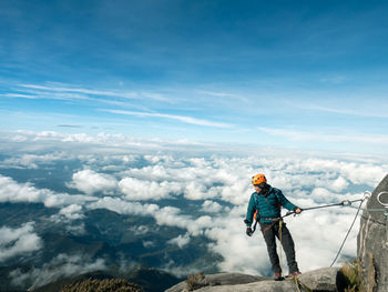 Man hiking on mountain against sky