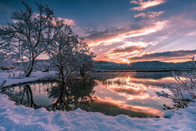 Scenic view of frozen lake against sky during sunset