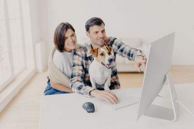 Couple working on desktop pc at home