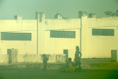 People in front of building against sky