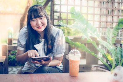 Portrait of young woman sitting outdoors