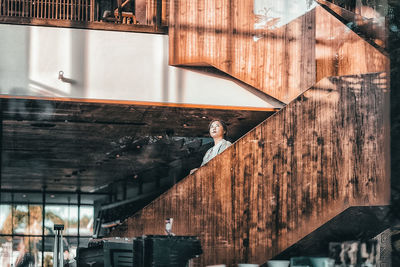 Reflection of woman standing on window of building