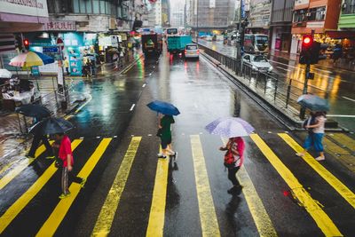 People walking on wet road in rainy season