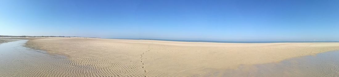 Scenic view of beach against clear blue sky