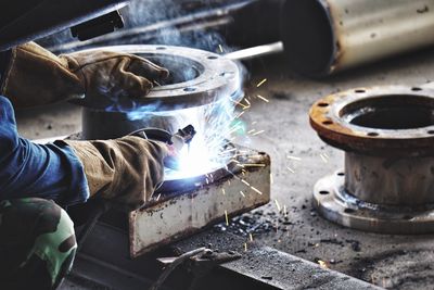 Close-up of man working on metal at workshop