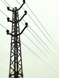 Low angle view of electricity pylon against clear sky