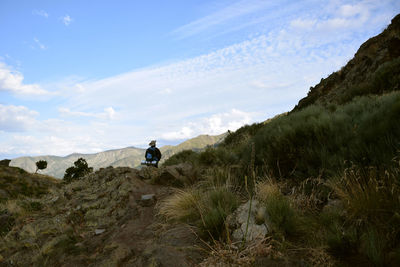 Man on arid landscape against sky