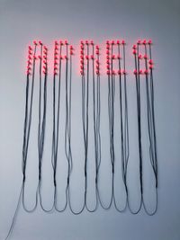 Low angle view of illuminated text with cables hanging on wall