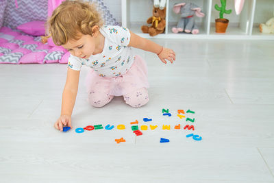 High angle view of cute girl playing with toys on floor