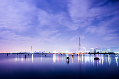 Calm sea with illuminated structures in background