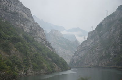 Scenic view of river amidst mountains against sky