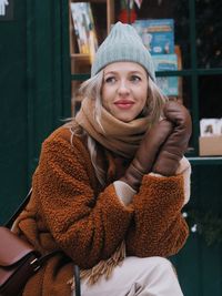 Young stylish blonde woman enjoying winter holidays on christmas market.