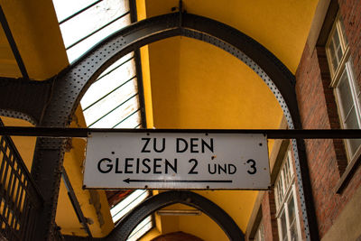 Low angle view of information sign hanging against ceiling