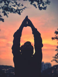 Silhouette woman standing against sky during sunset