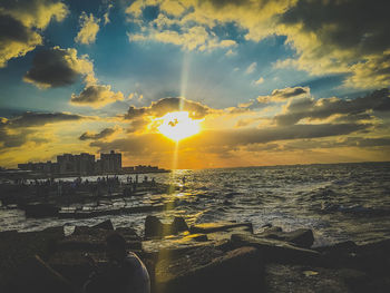 Scenic view of sea against cloudy sky during sunset