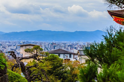 Houses and trees against sky