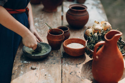 Midsection of woman preparing food at table outdoors