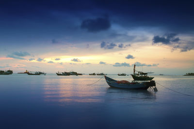 View of boats in the sea at sunset