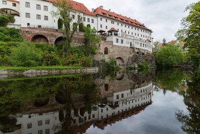 Arch bridge over river against buildings