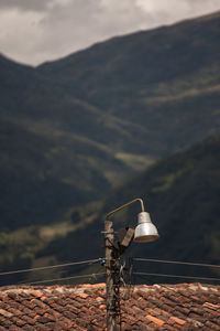 Old street light with copy space and electric cables, mountain in the background