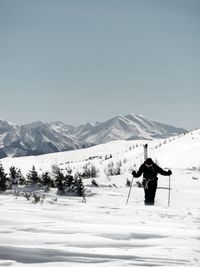 Man on snow covered mountain against sky