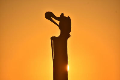Silhouette statue against clear sky during sunset