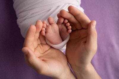 Cropped hand of doctor holding baby