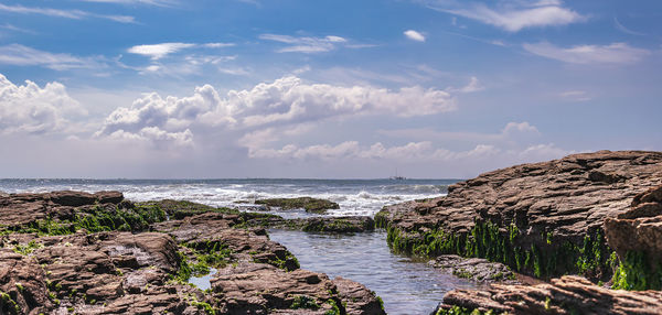 Views of the coast of west africa in ghana with cliffs and fishing boat on the horizon