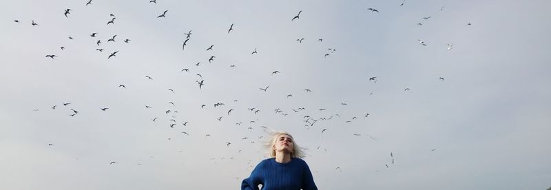 Woman flying against sky