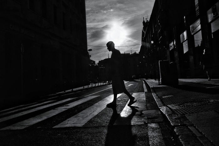 building exterior, full length, architecture, built structure, lifestyles, street, walking, sky, city, leisure activity, rear view, sunlight, men, city life, silhouette, casual clothing, shadow, cloud - sky