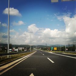 Empty road leading towards dramatic sky