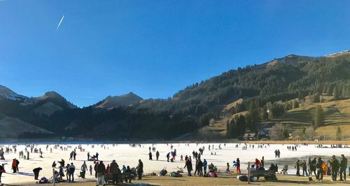 People on mountain against blue sky