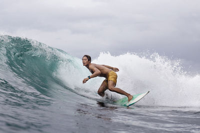 Dedicated young man surfing on sea