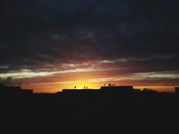 Silhouette buildings against sky during sunset