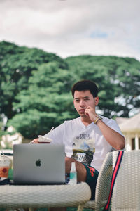 Portrait of young man sitting on table