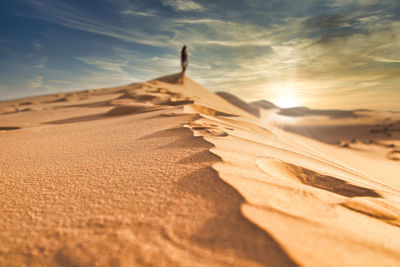 Surface level of sand dunes against sky