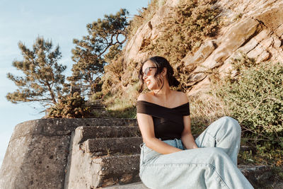 Young woman sitting on rock