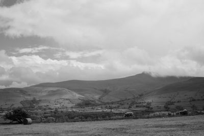 Scenic view of field and mountains against sky