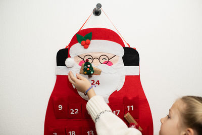 High angle view of girl holding gift against white background