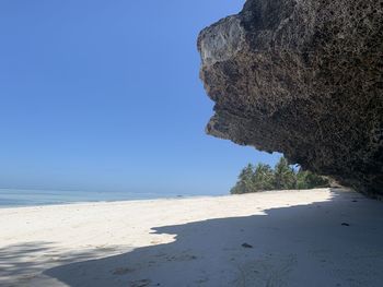 Scenic view of beach against clear blue sky