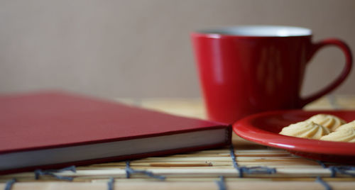 Close-up of coffee and book with cookie on table