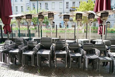 Empty chairs and tables on street in city