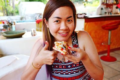 Portrait of woman gesturing while eating at restaurant