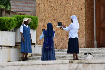 Rear view of friends standing on cross