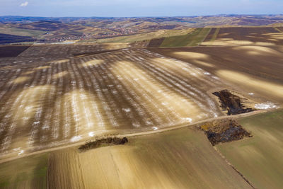 Aerial view of white chemical fertilizer, manure on agriculture farm, plowed soil. 