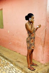 Rear view of woman standing against wall