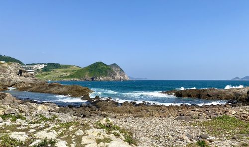 Scenic view of beach against clear blue sky