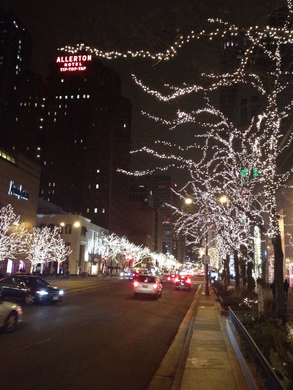 ILLUMINATED CITY STREET AGAINST SKY