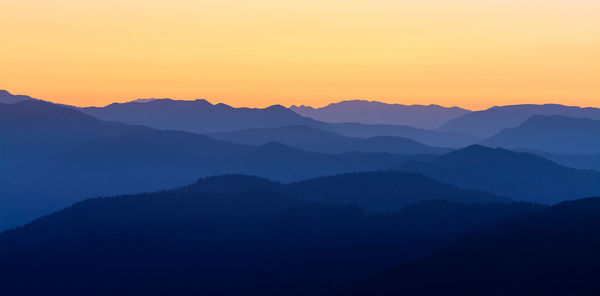 Scenic view of silhouette mountains against sky during sunset